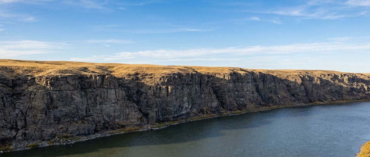 Layered shale and sandstone bluffs above the Missouri River in central Montana